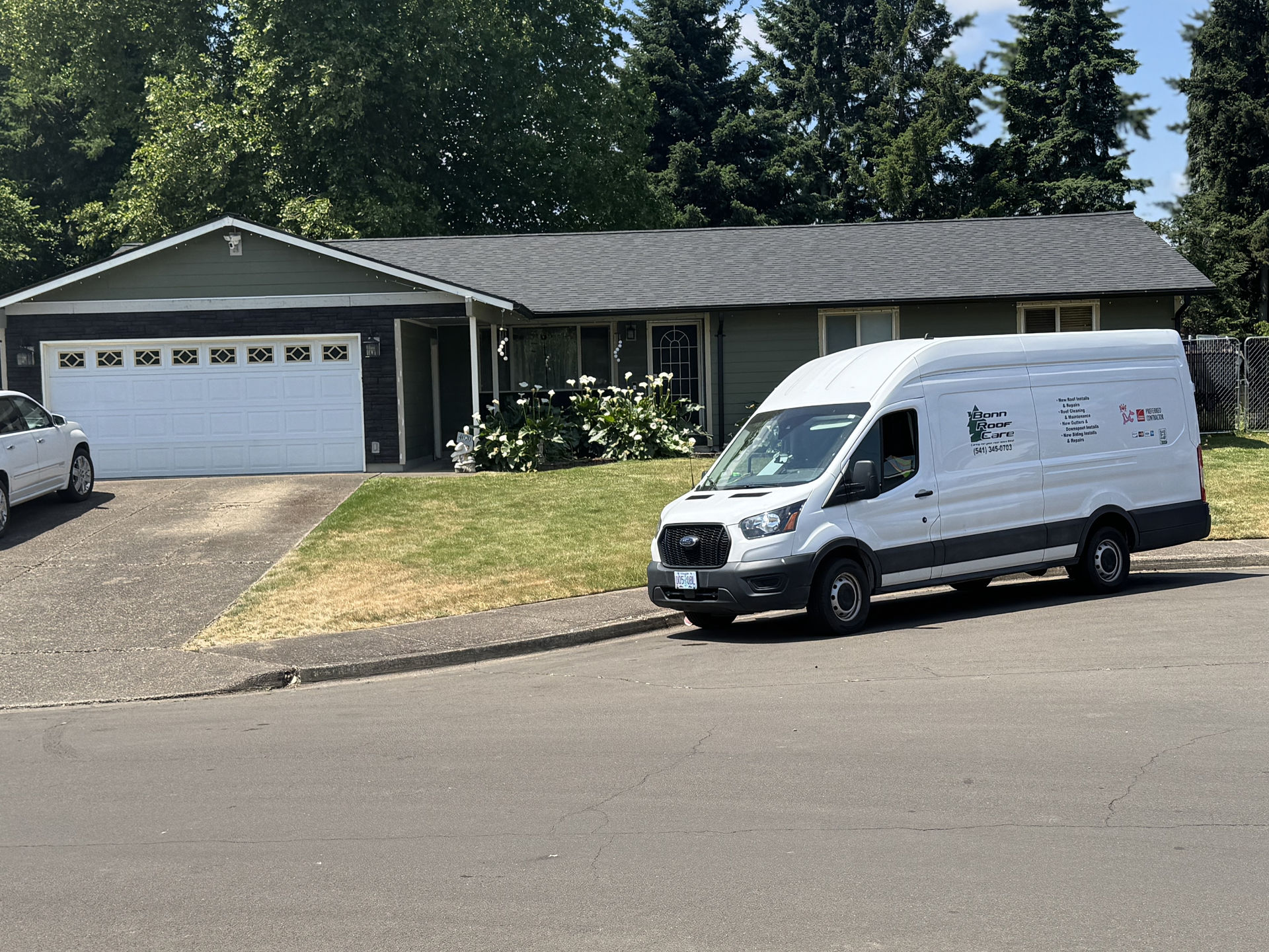 Bonn Roof Care service van parked outside a Eugene home with a newly finished roof